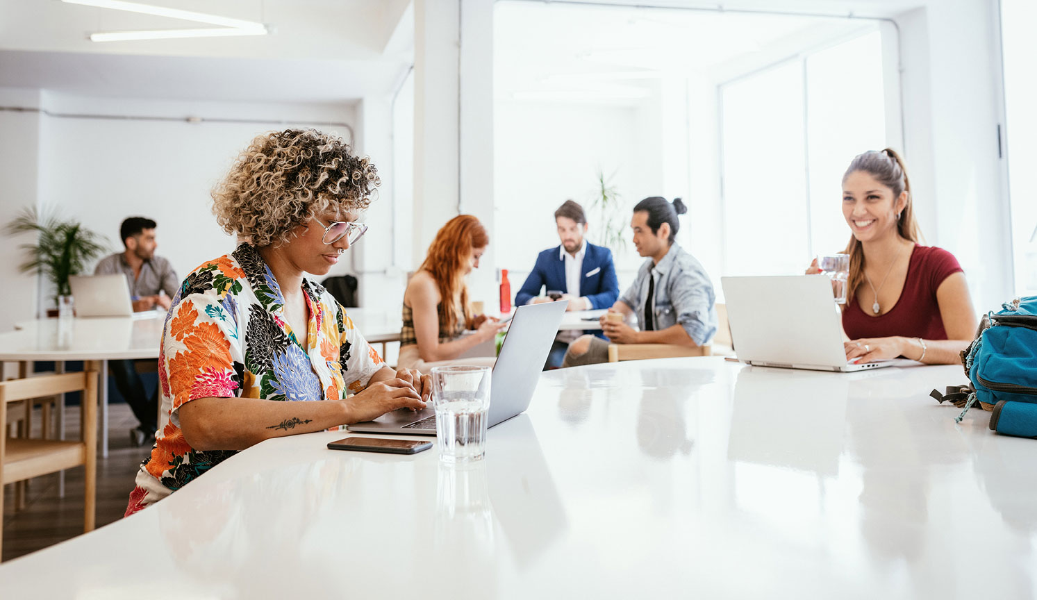 contemporary office with two women working on laptops in the foreground